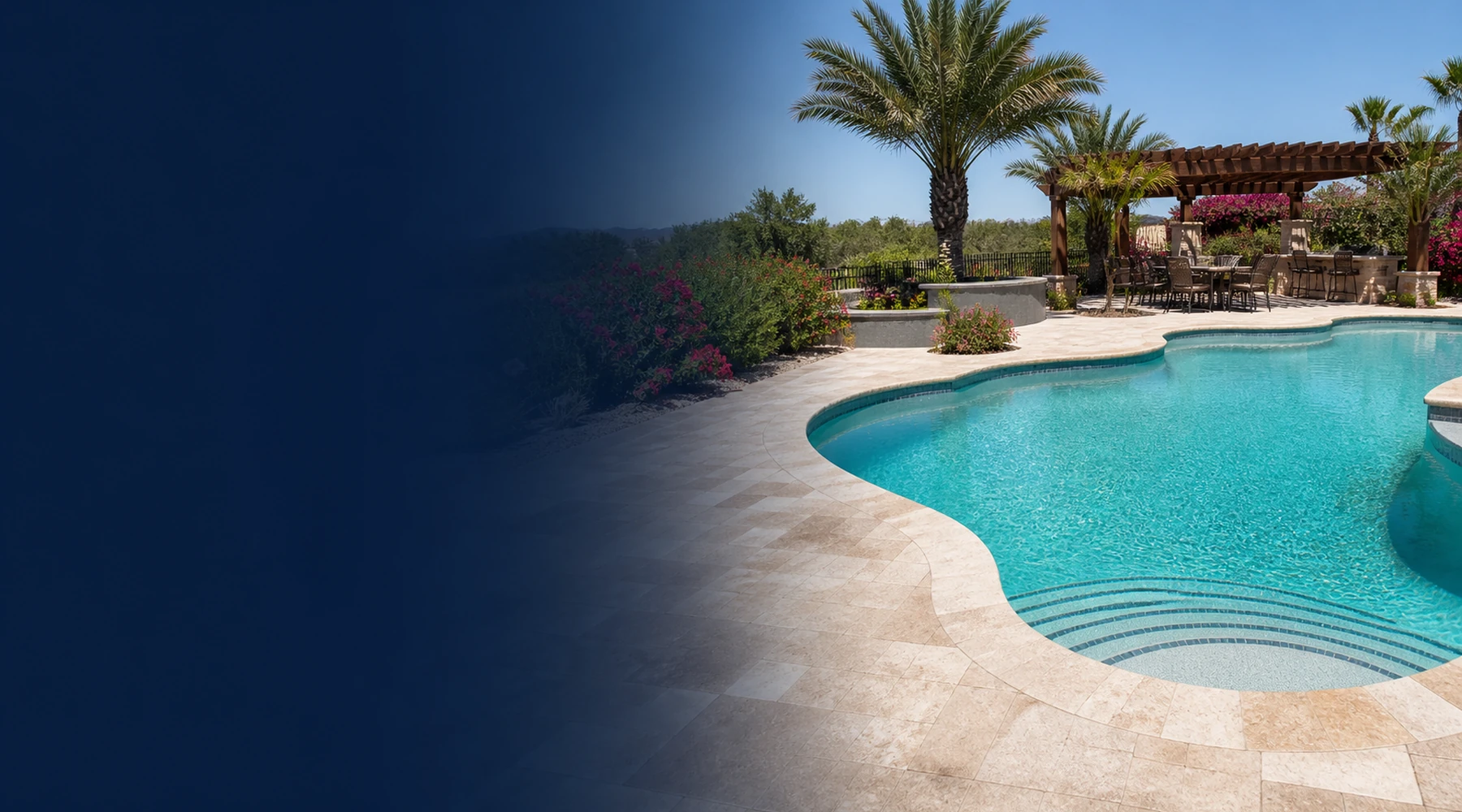 Bright freeform Arizona pool with clear water, curved entry steps, travertine deck, desert landscaping, and a shaded seating area.